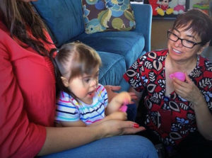 ECI staff member having a cup of tea with down syndrome toddler girl and mother